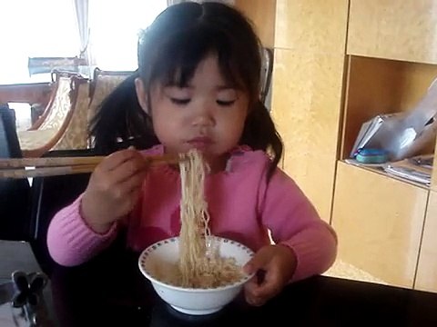 Emilyn eating noodles w/ chopsticks...