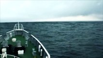 Japan, Tsunami. Coast Guard ship rides over the tsunami waves. 日本 - 津波