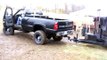 Lifted Duramax pulling dump trailer out of mud