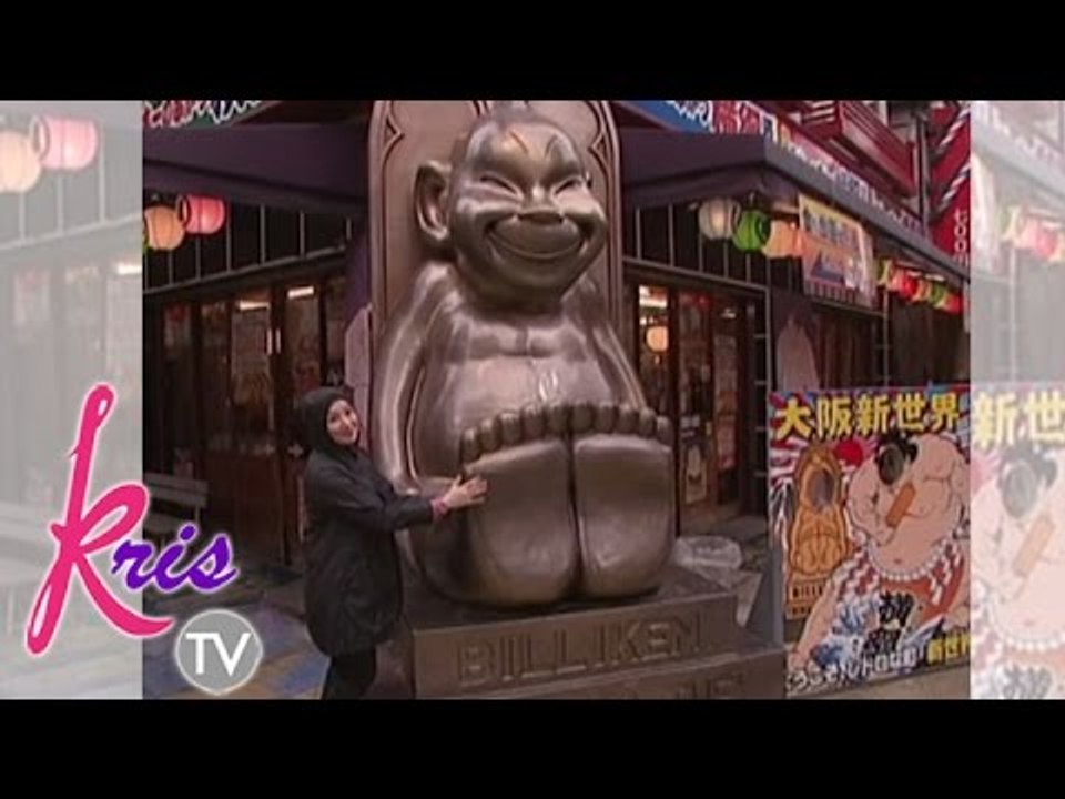 Kris takes a picture beside Billiken