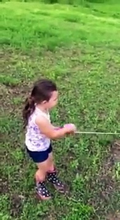 Une petite fille attrape un poisson aussi gros...
