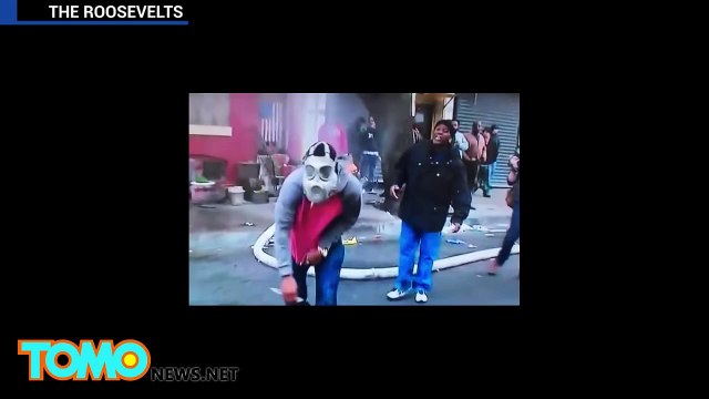 أحد الملثمين يقطع خرطوم مياه الإطفاء أثناء احتجاجات بالتيمور