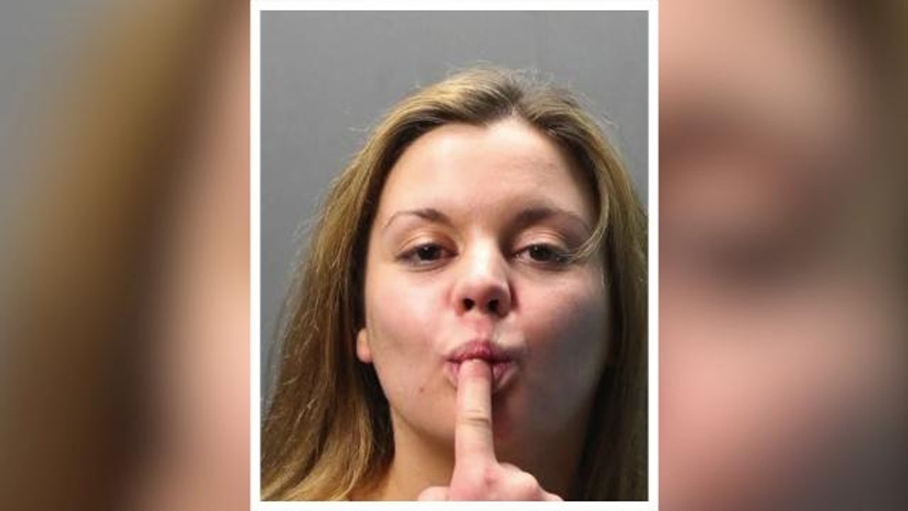 Woman sucks on finger in mugshot