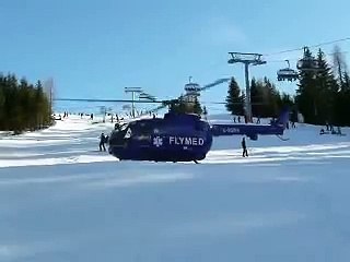 Rescue helicopter taking off from ski run