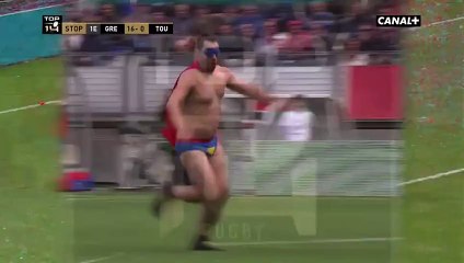 Un supporter déguisé en Superman retourne un stadier pendant un match de rugby