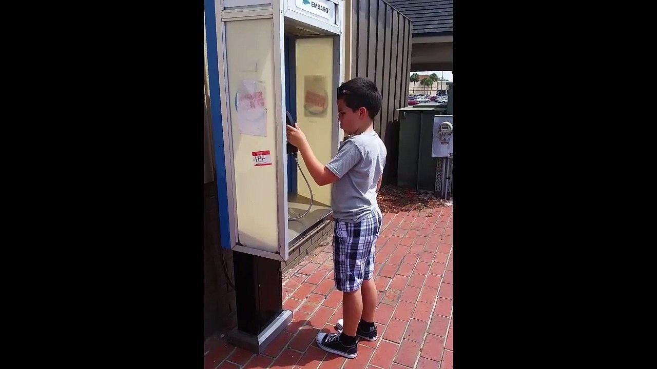 Enfant voit un téléphone public pour la première fois