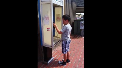 Enfant voit un téléphone public pour la première fois