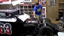 English guy Playing with a Dirt Modified Race car in Texas, in the shop.