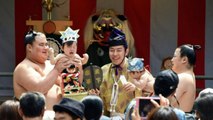 Sumo wrestlers hold screaming babies aloft in ancient crying contest
