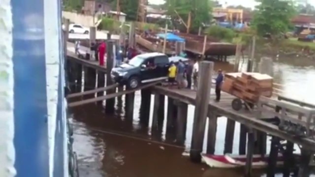 Un pick-up embarque sur un bateau avec deux planches