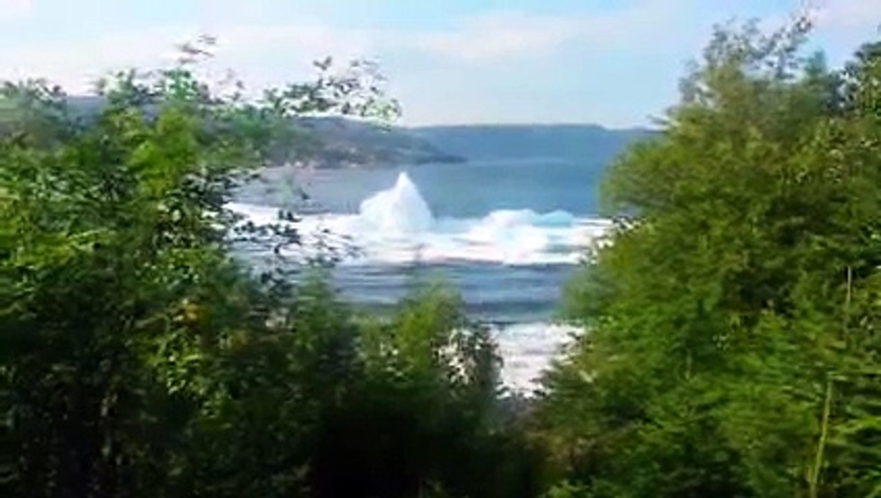 Iceberg rolling over and breaking.