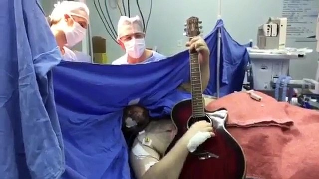 Un homme joue de la guitare pendant son opération du cerveau