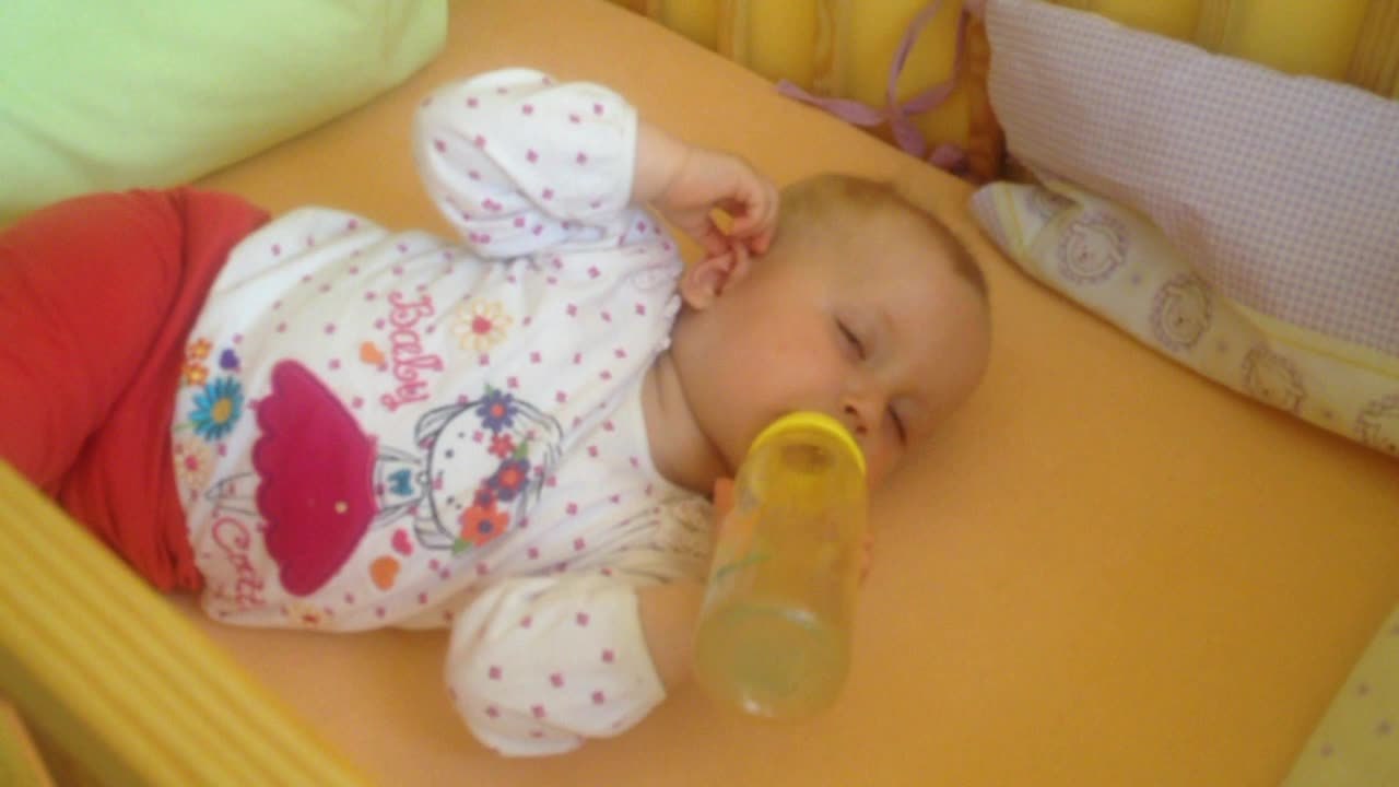 Sleepy baby falls asleep while drinking bottle