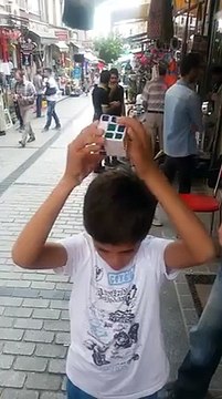 Un enfant syrien résout un Rubik's cube sans regarder et en parlant à des passants