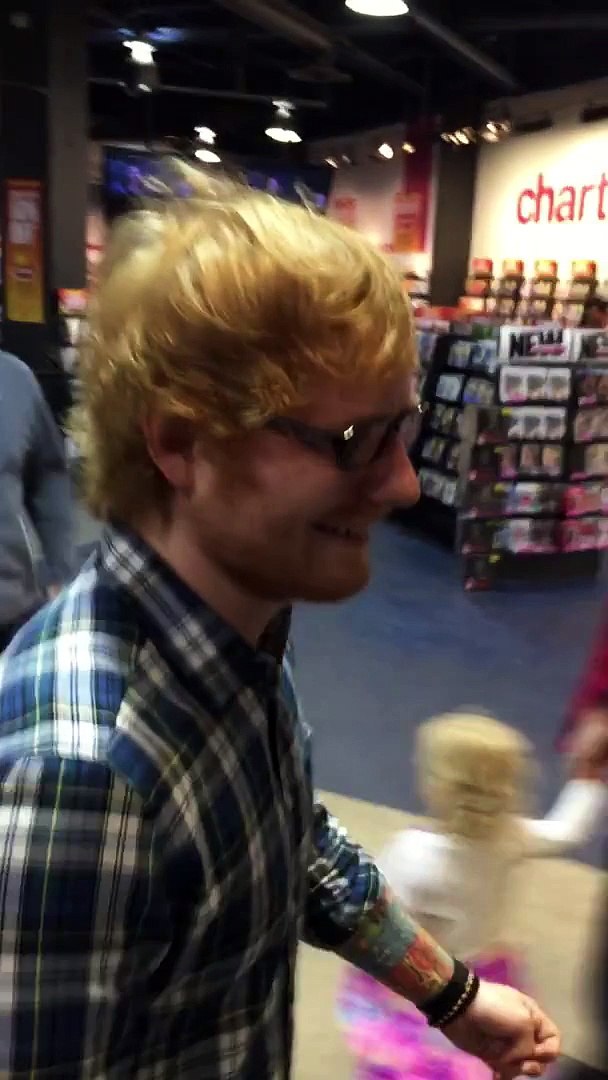 Ed Sheeran surprising a fan while she sings in front of a crowd at West Edmonton Mall