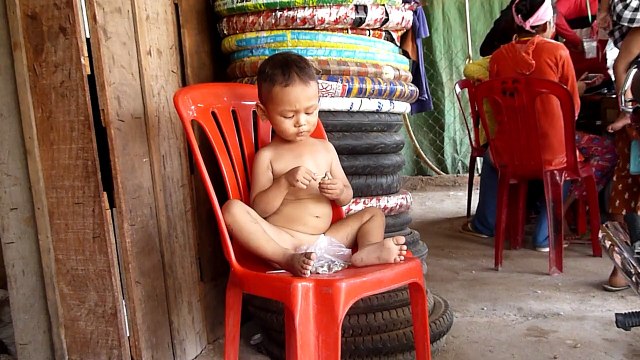 Dégustation d'escargots par un petit cambodgien