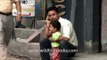 Nepalese upwardly mobile man speaks on phone, with kid in lap