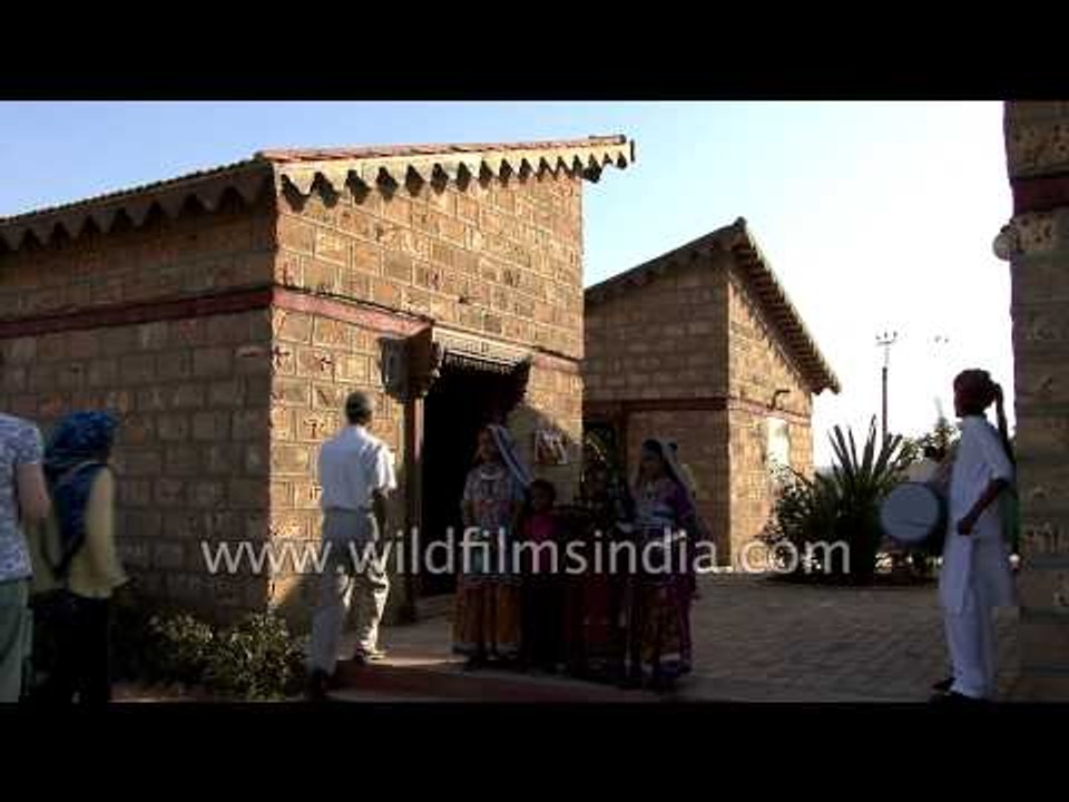 Visitors pose for a photo with women wearing traditional Gujarati attire