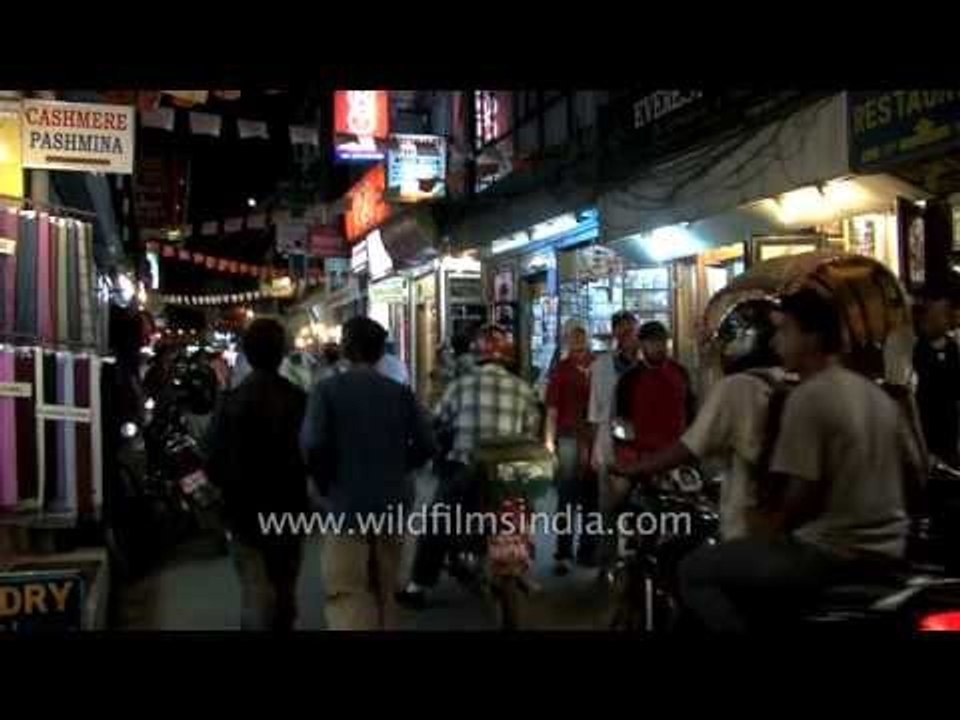 TNT Courier signboard and Buddhist thangkas for sale in Nepal's Thamel, at night