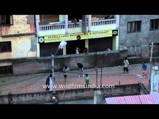 Children play football on the street in Kathmandu city