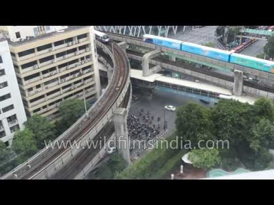 Sky trains whiz past the complex and layered Asian cityscape of Bangkok