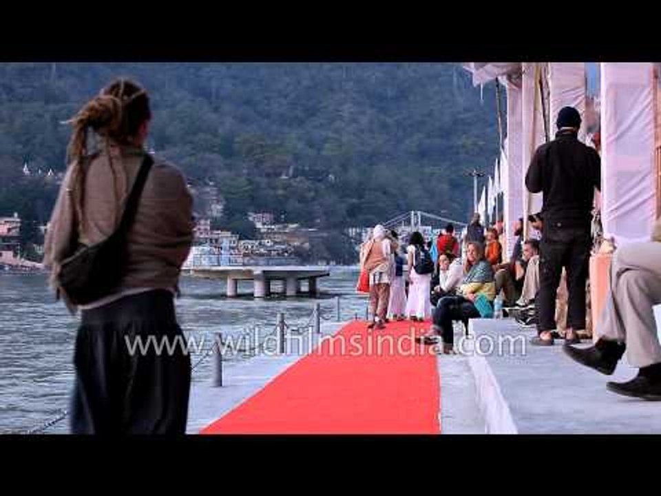 People relax on the banks of the Ganga river in Rishikesh