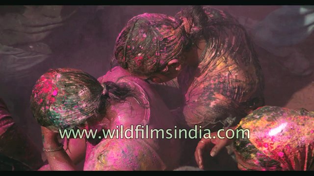 People throw colours on each other during Holi festival celebrations