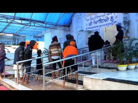 Sikh devotees wash their feet before entering Baba Guru Dutta Gurudwara in Punjab
