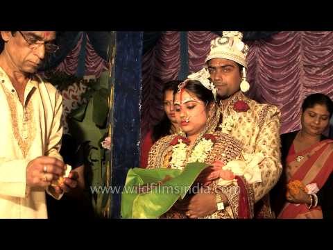 Bride's father performs rituals at Bengali wedding