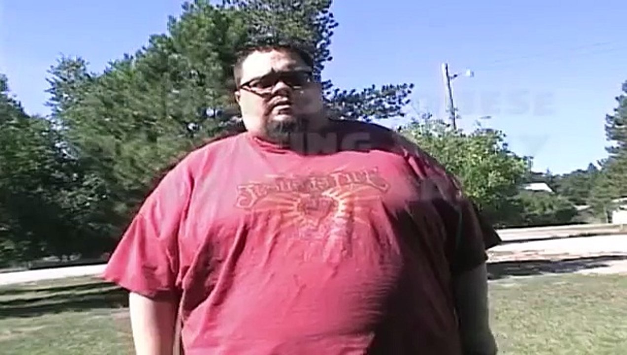 Morbidly Obese Man Eating a Tiny Candy Bar