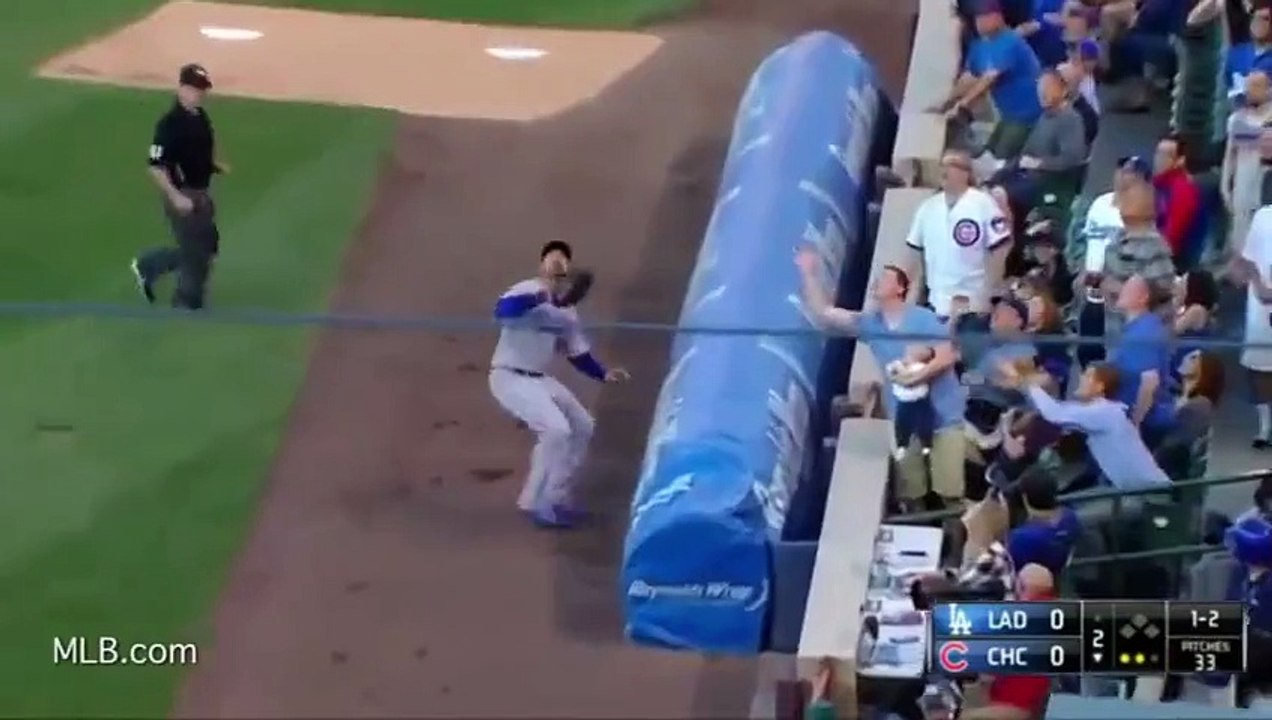 Un spectateur avec son bébé dans les bras vole une balle à un joueur de baseball