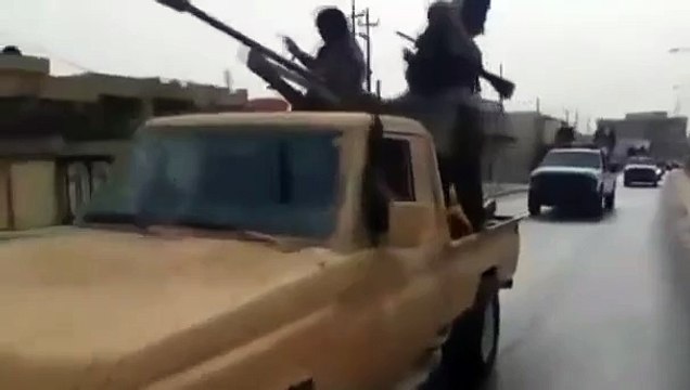 Islamic militants parade in captured Iraqi military vehicles in Mosul