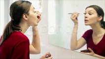 Young beautiful woman applying makeup on eyelid with brush HD. Stock Footage