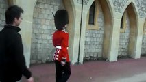 Un garde royal menace un touriste avec son arme