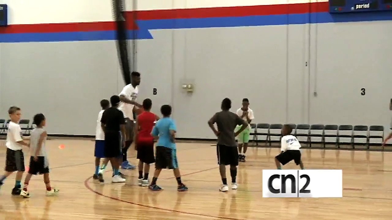 Un joueur de NBA dunk en sautant au dessus d'un...