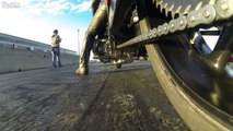Un biker fixe une caméra GoPro pour filmer la chaine de sa moto