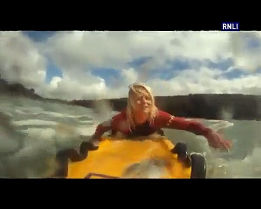 RNLI Lifeguard on Poldhu Cover beach rescue surfer from strong rip current
