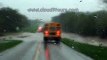 Bus drives through flooded road