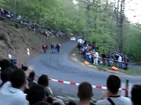 Des jeunes courent sur la route pendant une course de rallye et empêche une voiture de passer.