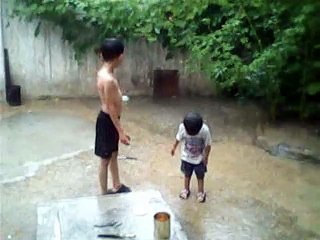 TWO KIDS, PLAYING IN RAIN, IN KARACHI