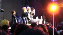 Meninos do Cross Gene beijando suas garrafas após dois participantes do concurso se beijarem no palco