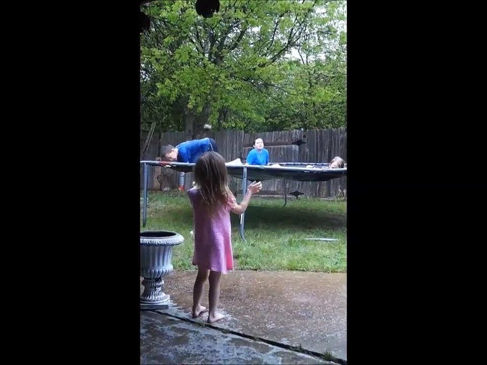 kids playing in the rain on soapy trampoline.