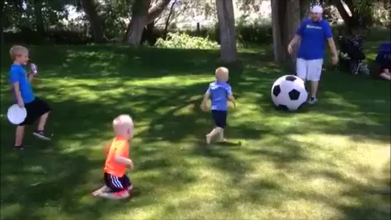 Man kicks large soccer ball and knocks down his kid!