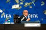 Lee Nelson balance des billets sur Sepp Blatter lors d'une conférence de presse
