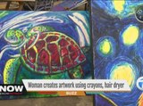 Woman creates artwork using crayons, hair dryer