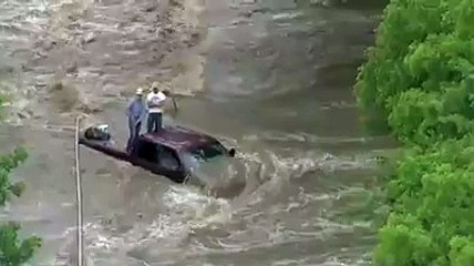 Helicopter rescue of flood victims surrounded by rushing water