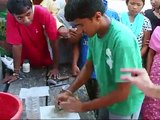 Nepali deaf art students demonstrate how to mount wall mosaics