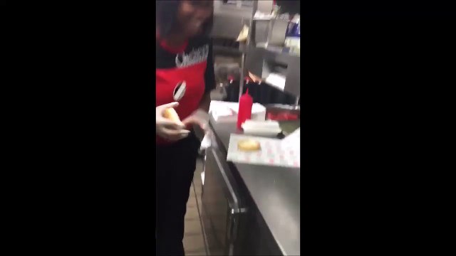 Une employée de Fast Food frotte le pain burger au sol et l'utilise pour préparer un hamburger