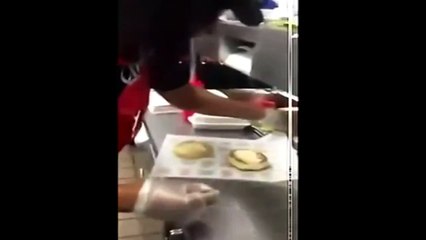 Cette employée fait un hamburger pour un client avec un pain qu'elle a utilisé comme une serpillière