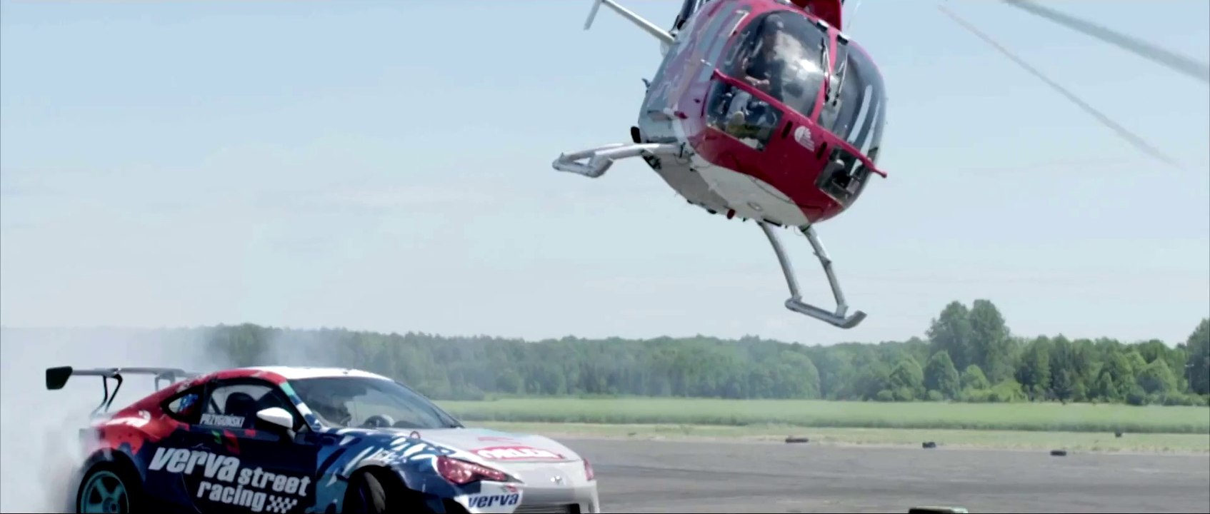 Helicopter closely chases a race car in this insane stunt
